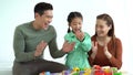 Portrait of young Asian family clapping and playing with toy blocks