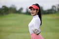 Portrait of young asian female golfer holding the golf club at the course Royalty Free Stock Photo