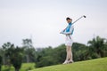 Portrait of young asian female golfer holding the golf club at the course Royalty Free Stock Photo