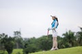 Portrait of young asian female golfer holding the golf club at the course Royalty Free Stock Photo