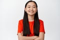 Portrait of young asian female student, smiling and looking happy, cross arms on chest, professional and confident pose Royalty Free Stock Photo