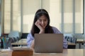 Portrait young asian girl looking camera while using laptop computer Royalty Free Stock Photo