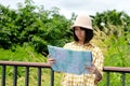 Portrait of young asian girl traveler holding map while standing in outdoors nature background, travel spring, summer holiday Royalty Free Stock Photo