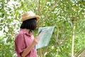 Portrait of young asian girl traveler holding map while standing in outdoors nature background, travel spring, summer holiday Royalty Free Stock Photo