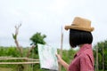 Portrait of young asian girl traveler holding map while standing in outdoors nature background, travel spring, summer holiday vaca Royalty Free Stock Photo