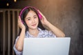 Portrait of Young asian happiness wearing headphones using laptop computer at home for working Royalty Free Stock Photo