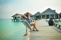 Portrait of young asian looking woman pretending touching a bird at tropical beach at Maldives