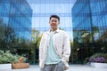 Portrait of a young Asian male businessman, programmer, freelancer standing in an outdoor office center, holding his Royalty Free Stock Photo