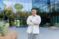 Portrait of a young Asian man designer, architect standing outside a modern building, office, crossed his arms Royalty Free Stock Photo