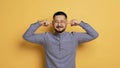 Portrait of young asian man plugging ears with fingers and frowning Royalty Free Stock Photo