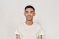 Portrait of young asian man with problematic skin and hyperpigmentation on his face smiling at camera isolated over