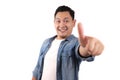 Portrait of young Asian man shows thumbs up sign, happy smiling person, OK deal Royalty Free Stock Photo