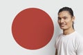 Portrait of young Asian man smiling against Japanese flag Royalty Free Stock Photo