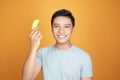 Portrait of young Asian man smiling while holding small banana