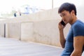 Portrait of young Asian man talking on the phone in the city outdoors Royalty Free Stock Photo