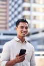 A portrait of a young Asian millenial man on his cellphone in the city Royalty Free Stock Photo