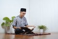 Portrait of Young Asian Muslim man reading holy Qur`an on Ramadan Kareem Royalty Free Stock Photo