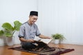 Portrait of Young Asian Muslim man reading holy Qur`an on Ramadan Kareem Royalty Free Stock Photo