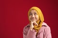 Portrait of young Asian muslim teenage girl wearing red hijab looking up and thinking Royalty Free Stock Photo