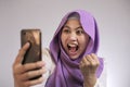 Young Muslim Woman Get Good News on Her Phone Royalty Free Stock Photo