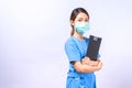 Portrait of young Asian nurse wearing surgical mask holding clipboard Royalty Free Stock Photo