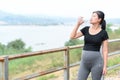 Portrait young Asian pregnant woman drinking clean water after her relaxing and workout in the park Royalty Free Stock Photo