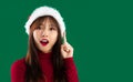 Portrait young asian pretty woman in red sweater wear santa hat looking camera finger pointing Royalty Free Stock Photo