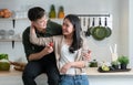 Portrait of young Asian romantic couple standing in the kitchen, happy lover hugging, smiling and looking at each other Royalty Free Stock Photo