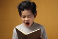 Portrait of young Asian student boy tired sleepy and yawning when reading a book, student tired when studying hard Royalty Free Stock Photo