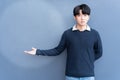 Portrait of Young Asian teenage cool hair stylish wearing blue sweater indicate highlight blank space for your text, design on blu