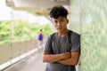 Young Asian tourist man as backpacker with arms crossed at the footbridge Royalty Free Stock Photo