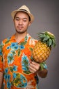 Portrait of young Asian tourist man holding pineapple Royalty Free Stock Photo