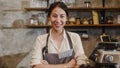 Portrait young Asian woman barista feeling happy smiling at urban cafe. Small business owner Indonesian girl in apron relax toothy Royalty Free Stock Photo