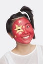 Portrait of young Asian woman with Chinese flag painted on face against white background Royalty Free Stock Photo