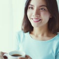 Portrait of young Asian woman drinking coffee behind the window Royalty Free Stock Photo