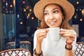 Young Asian woman drinking coffee in a cafe. Focus on white cup Royalty Free Stock Photo