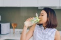 Portrait of young Asian woman drinking detox drink in the kitchen. Healthy concept, weight loss food concept Royalty Free Stock Photo