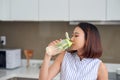 Portrait of young Asian woman drinking detox drink in the kitchen. Healthy concept, weight loss food concept Royalty Free Stock Photo