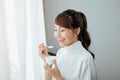 Portrait of young Asian woman eating yogurt behind the window Royalty Free Stock Photo