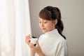 Portrait of young Asian woman eating yogurt behind the window Royalty Free Stock Photo