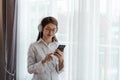 Young Asian woman enjoy listening to music with headphones while holding mobile phone, happy and relaxing time Royalty Free Stock Photo