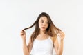 Portrait of young Asian woman frustrated with messed brunette hair on white background. Close up