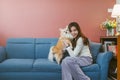 Portrait of young asian woman holding her dog chihuahua on sofa at home. Royalty Free Stock Photo