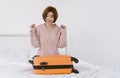 Portrait of young Asian woman packing to her clothes into suitcase bag preparing for travel summer trip on bed. Korean or Japanese Royalty Free Stock Photo