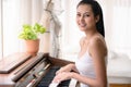 Portrait of young asian woman playing piano in living room at home Royalty Free Stock Photo