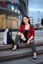 Portrait of young woman sitting on stairs in city at night and smiling to camera. Royalty Free Stock Photo