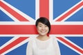 Portrait of young Asian woman smiling against British flag Royalty Free Stock Photo