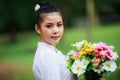 portrait of young asian woman standing wearing white traditional thai culture lanna dress style and flower on holding hand in Royalty Free Stock Photo