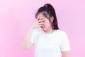 Portrait Young asian woman suffering from headache on pink background. Hiding her face and confused angry with unhappy sad Royalty Free Stock Photo