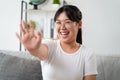 Portrait of young Asian woman wearing eye glasses big smiling and looking at camera with feeling happy and positive in living room Royalty Free Stock Photo